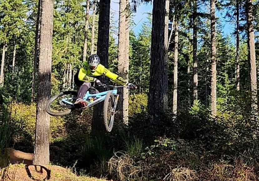 Mountain biker jumping through the air in the forest